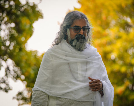 Mohanji in nature, yellow-green trees behind